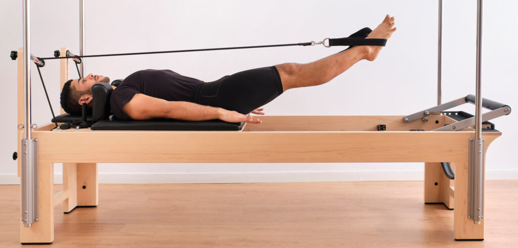 A man on a reformer pilates machine